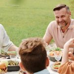 A cheerful family enjoying a meal together outdoors, sharing laughter and warmth.
