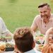 A cheerful family enjoying a meal together outdoors, sharing laughter and warmth.
