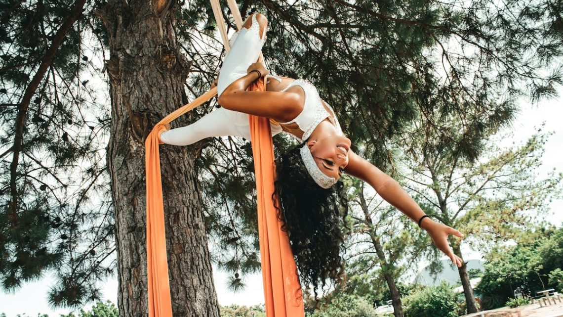A woman performing aerial dance on a tree, showcasing skill and flexibility in Candelária, Brasil.
